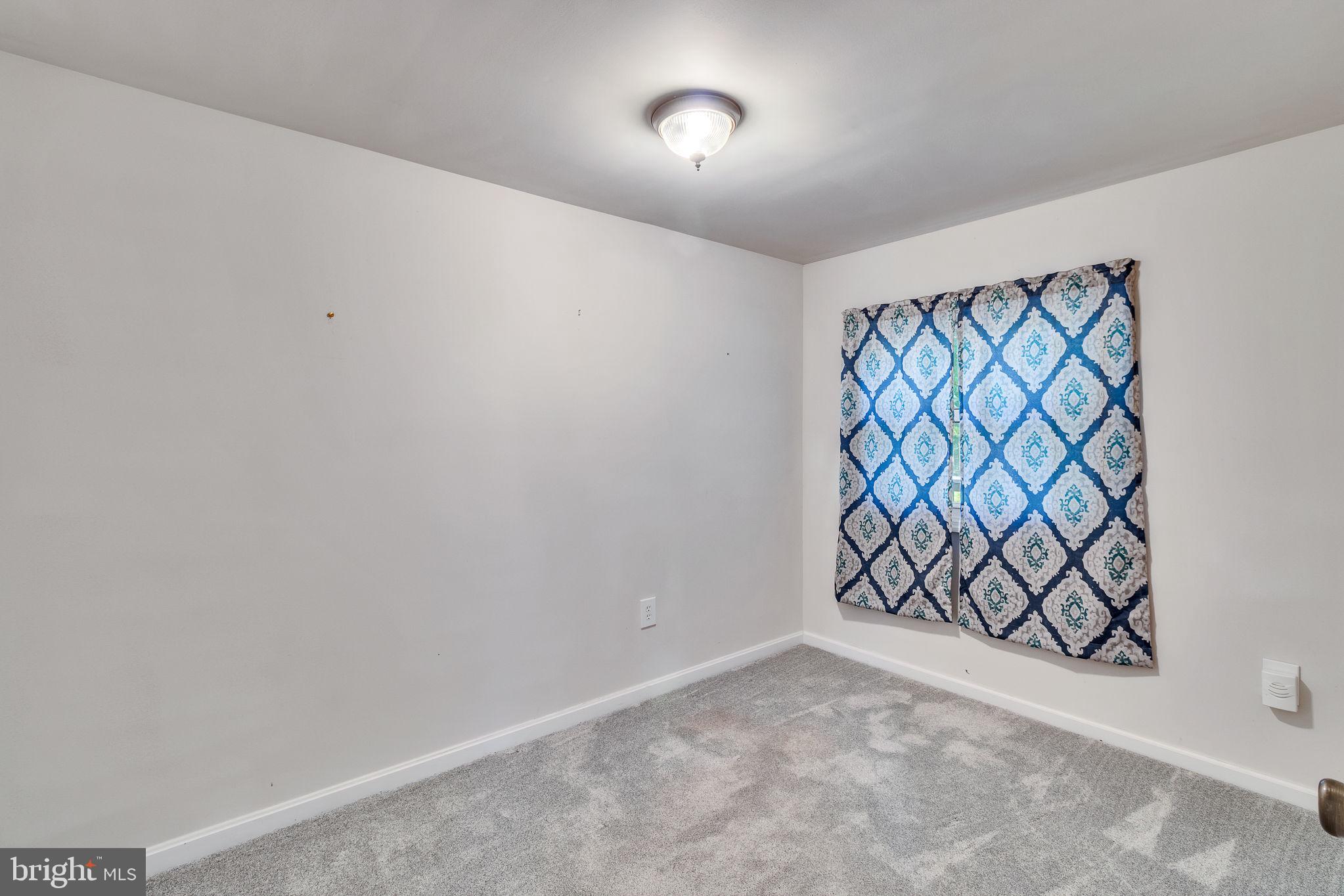 529 Taylors Beach Road Reedville, VA 22539 - Photo 16 of 57 Bright and airy room with patterned curtains.