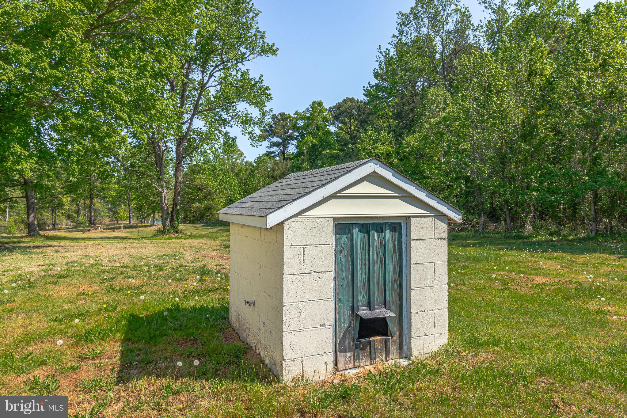 529 Taylors Beach Road Reedville, VA 22539 - Photo 57 of 57 Charming shed nestled in lush greenery.