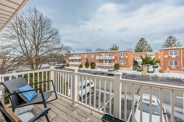 a view of a balcony with wooden chairs