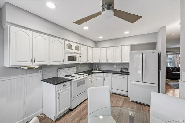 a kitchen with white cabinets and stainless steel appliances
