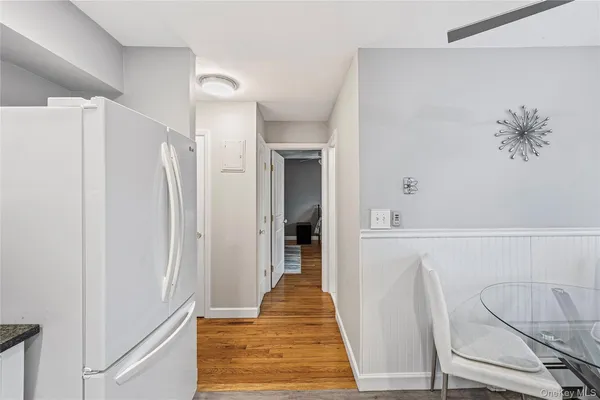 a hallway with white doors wooden floor and front door