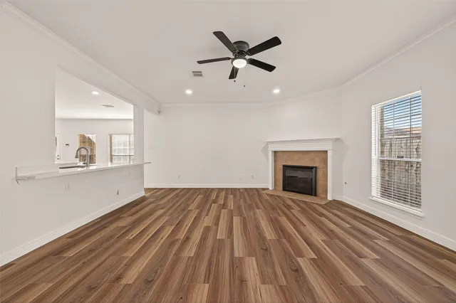 a view of empty room with wooden floor and fireplace