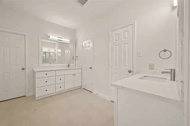 a spacious bathroom with 2 sink tub and a mirror