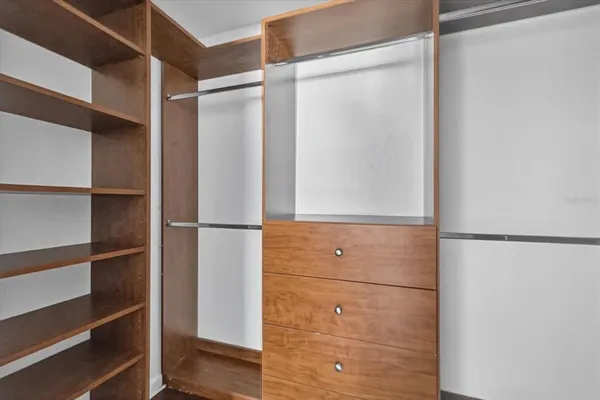 a view of walk in closet with empty racks