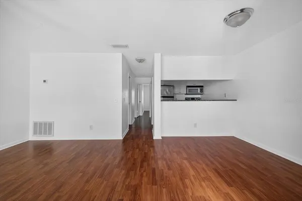 a view of a kitchen with wooden floor and electronic appliances