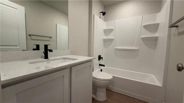 a living room with stainless steel appliances furniture and kitchen view