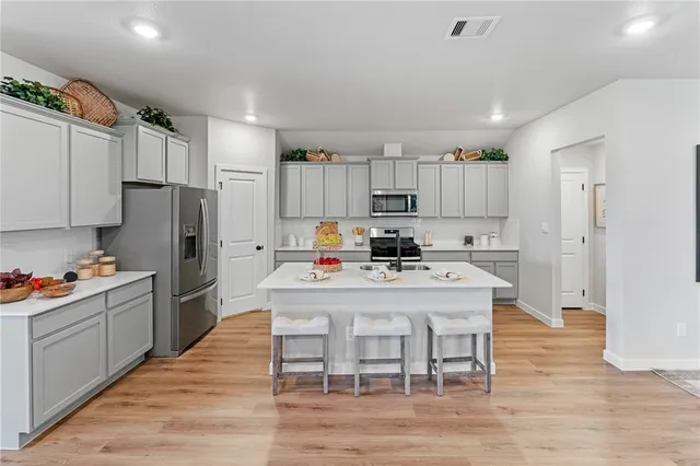 a kitchen with kitchen island a white cabinets and refrigerator