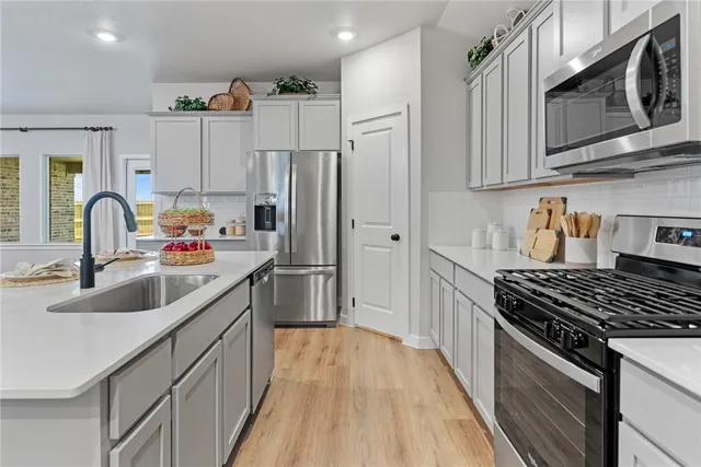 a kitchen with stainless steel appliances a sink stove and refrigerator