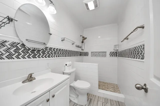 a bathroom with a sink a toilet and shower