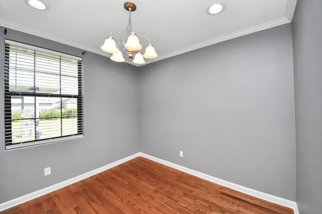 a large kitchen with cabinets a sink dishwasher a stove and a dining table with wooden floor