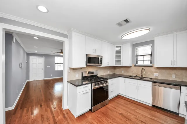 a kitchen with granite countertop a refrigerator and cabinets