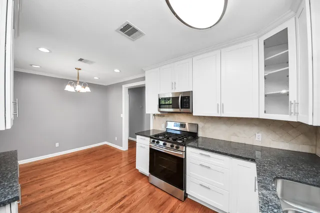 a kitchen with a wooden floor and cabinets