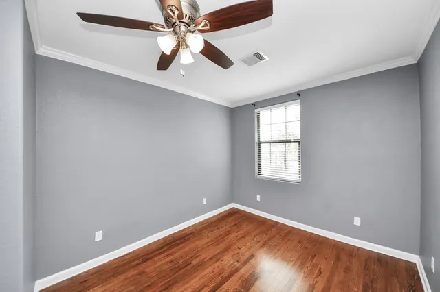 an empty room with a window and a fan