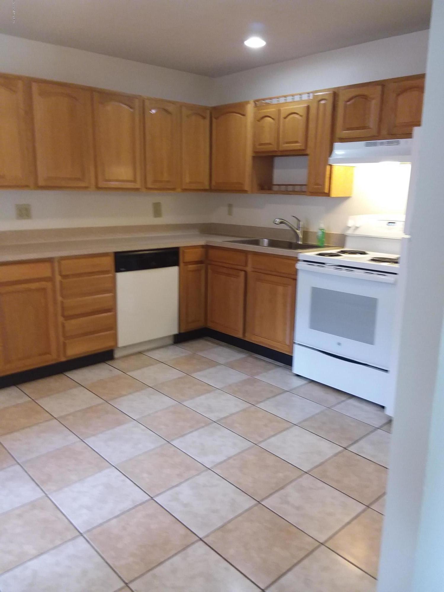 7311 Melvin Road Jacksonville, FL 32210 - Photo 3 of 24 a kitchen with a sink a stove and cabinets