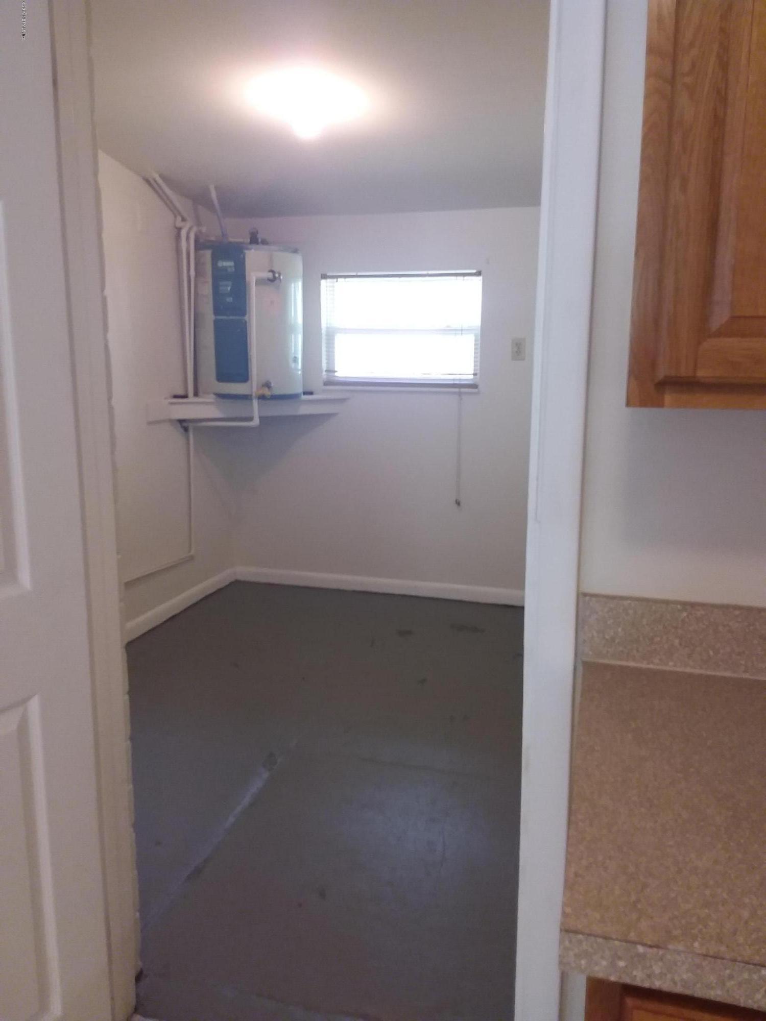 7311 Melvin Road Jacksonville, FL 32210 - Photo 7 of 24 an empty room with wooden floor and windows