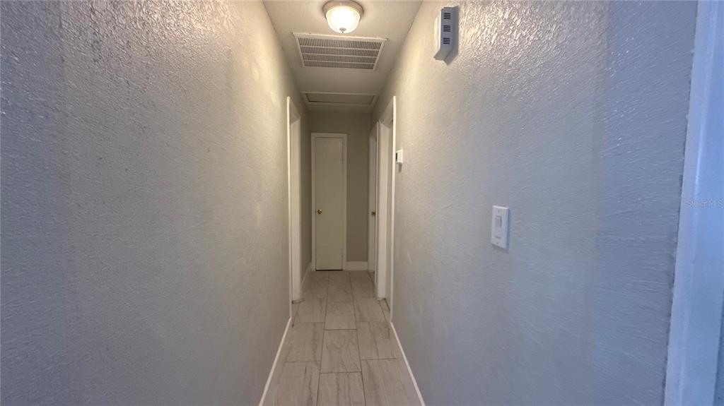 8106 Wichita Way Tampa, FL 33619 - Photo 13 of 21 a view of a hallway with wooden floor