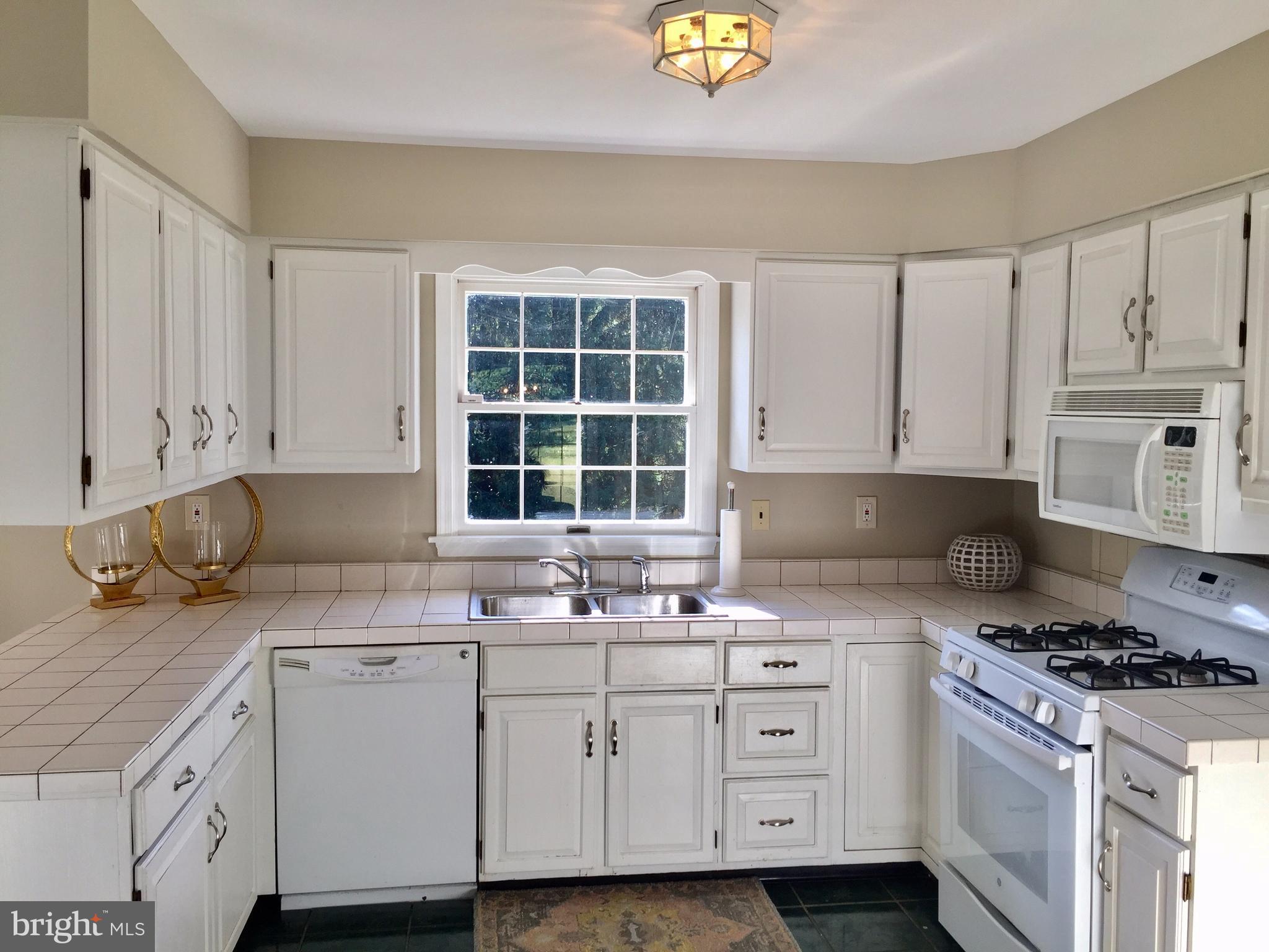 14220 Manor Road Phoenix, MD 21131 - Photo 12 of 25 a kitchen with cabinets appliances a sink and a window