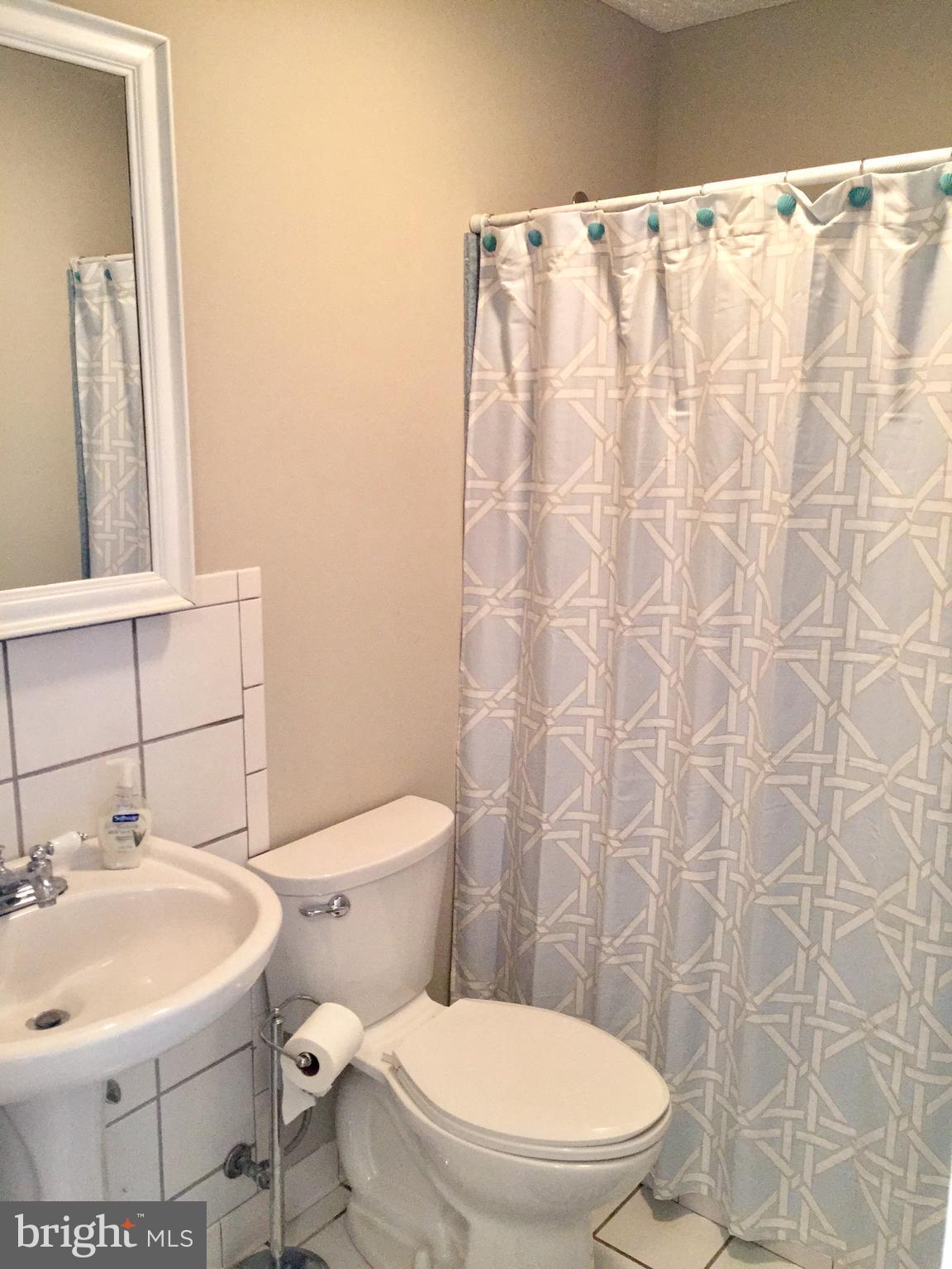 14220 Manor Road Phoenix, MD 21131 - Photo 21 of 25 a white toilet sitting next to a white sink and a mirror