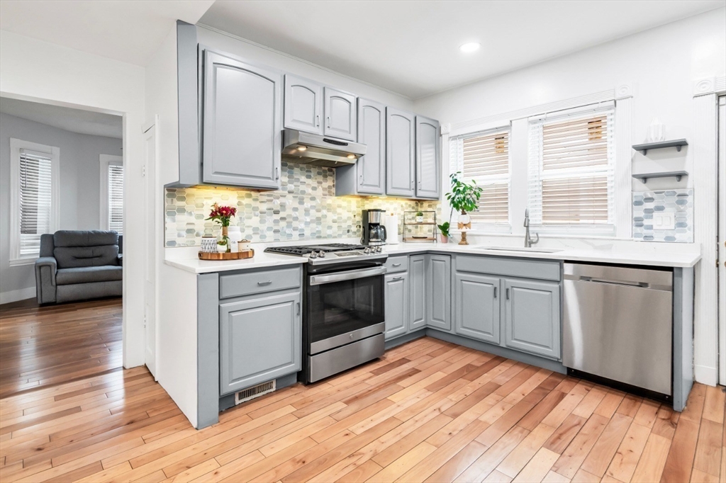 42 D Street Lowell, MA 01851 - Photo 12 of 27 a kitchen with granite countertop white cabinets and white appliances