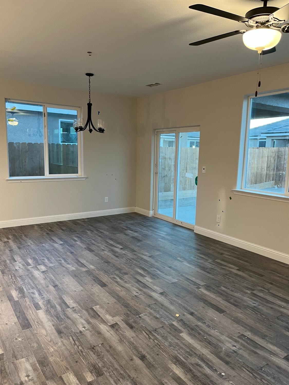 1189 Emerald Way Kerman, CA 93630 - Photo 3 of 3 a view of an empty room with wooden floor and a window