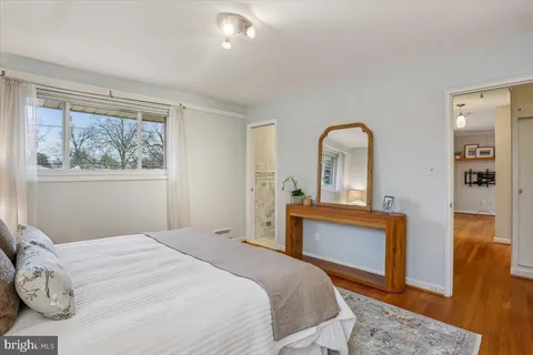 a bedroom with a bed and a dresser next to a window
