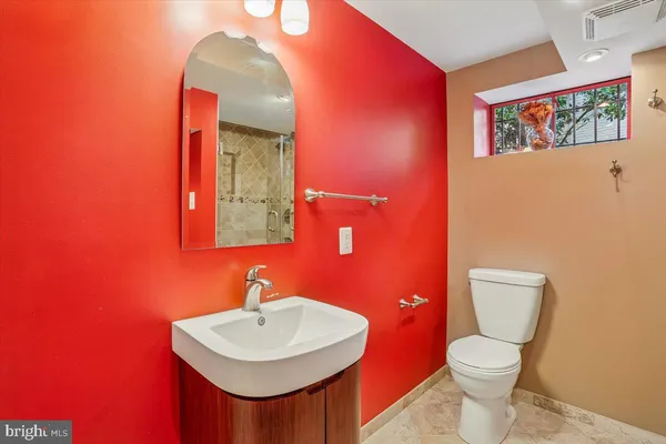 a bathroom with a toilet a sink and mirror
