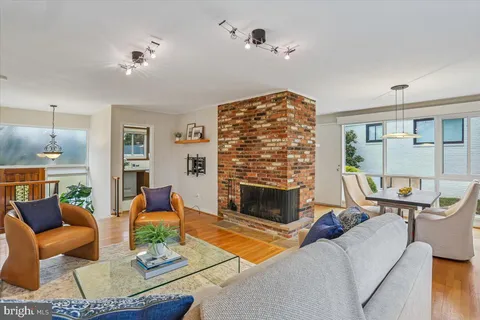 a living room with furniture a fireplace and a chandelier