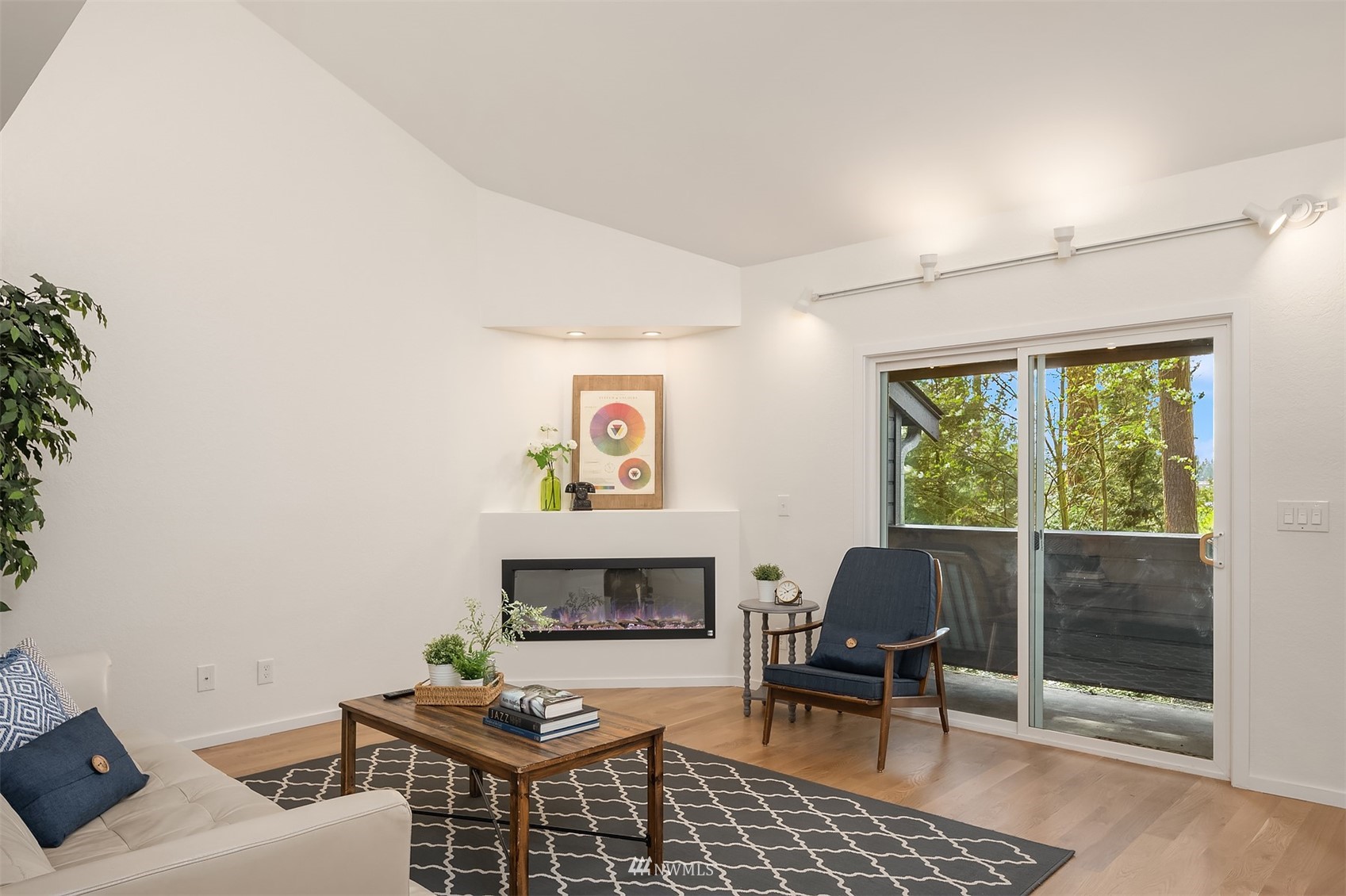 8418 240th Street Southwest, Unit A303 Edmonds, WA 98026 - Photo 2 of 23 a living room with furniture a rug and a fireplace