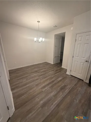 an empty room with wooden floor and window