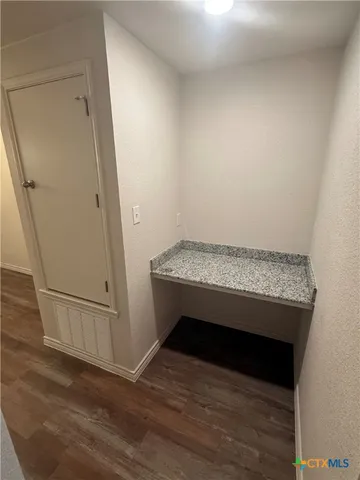 a room with wooden floor and white walls