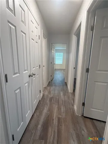 a view of a hallway with wooden floor