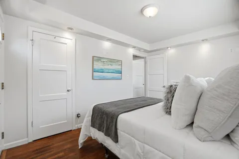 a bedroom with a bed and a painting on the wall