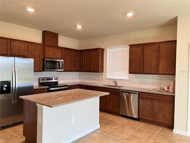a kitchen with stainless steel appliances wooden cabinets a sink and a stove