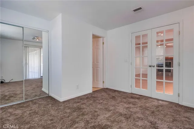 a view of an empty room with wooden floor and windows