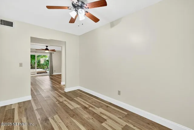 a view of empty room with wooden floor
