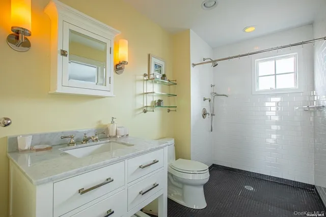 a bathroom with a granite countertop sink toilet and shower