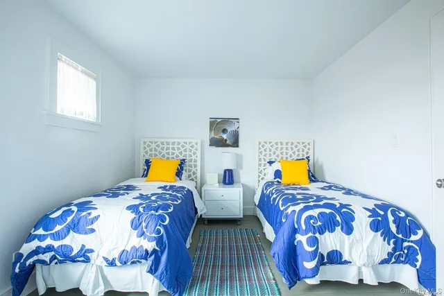 a bedroom with two beds and a lamp