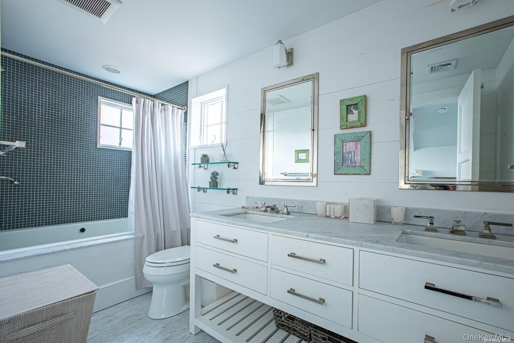 11 Captree Island Babylon, NY 11702 - Photo 27 of 31 a bathroom with a double vanity sink toilet mirror and bathtub
