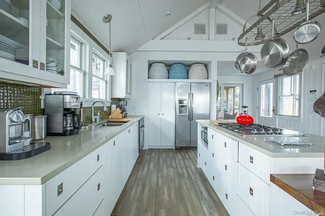 a kitchen with stainless steel appliances cabinets a large window and stainless steel appliances