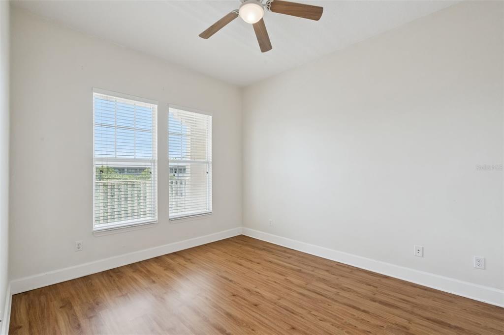 1400 Celebration Avenue, Unit 305 Celebration, FL 34747 - Photo 13 of 38 an empty room with wooden floor cabinet and windows