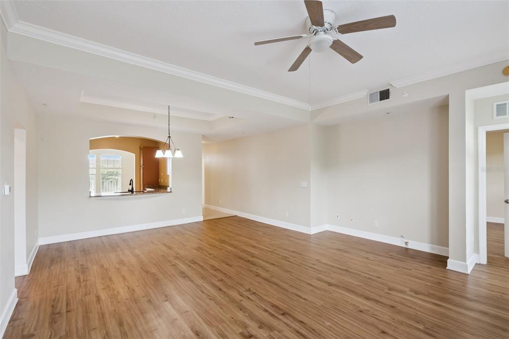 1400 Celebration Avenue, Unit 305 Celebration, FL 34747 - Photo 16 of 38 an empty room with wooden floor chandelier fan and windows