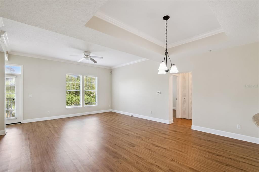 1400 Celebration Avenue, Unit 305 Celebration, FL 34747 - Photo 18 of 38 an empty room with wooden floor chandelier and windows