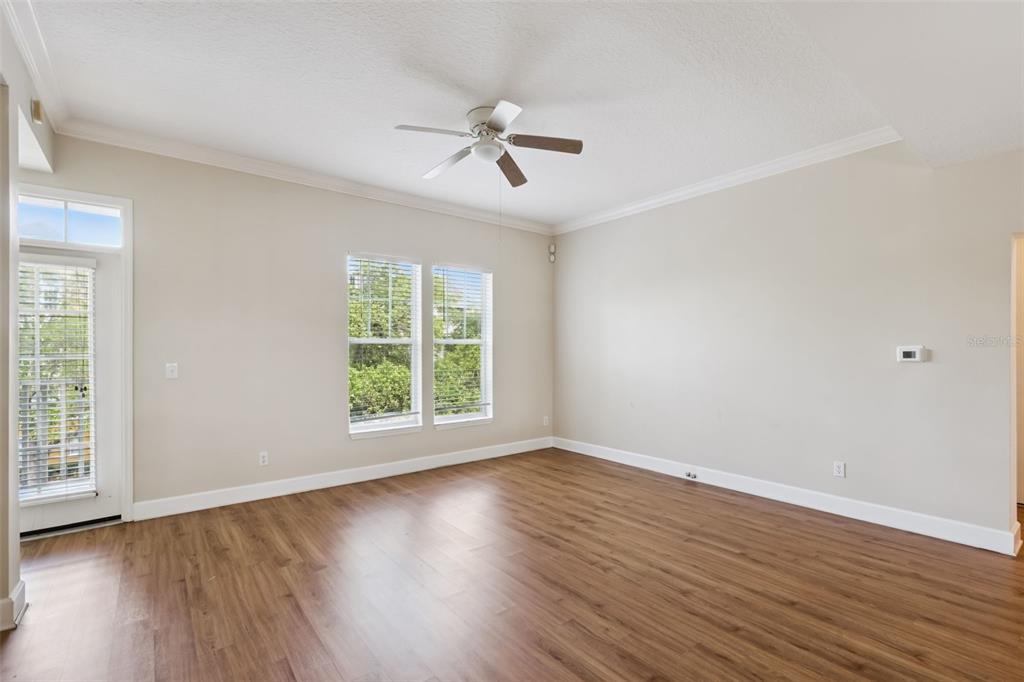 1400 Celebration Avenue, Unit 305 Celebration, FL 34747 - Photo 20 of 38 an empty room with wooden floor fan and windows