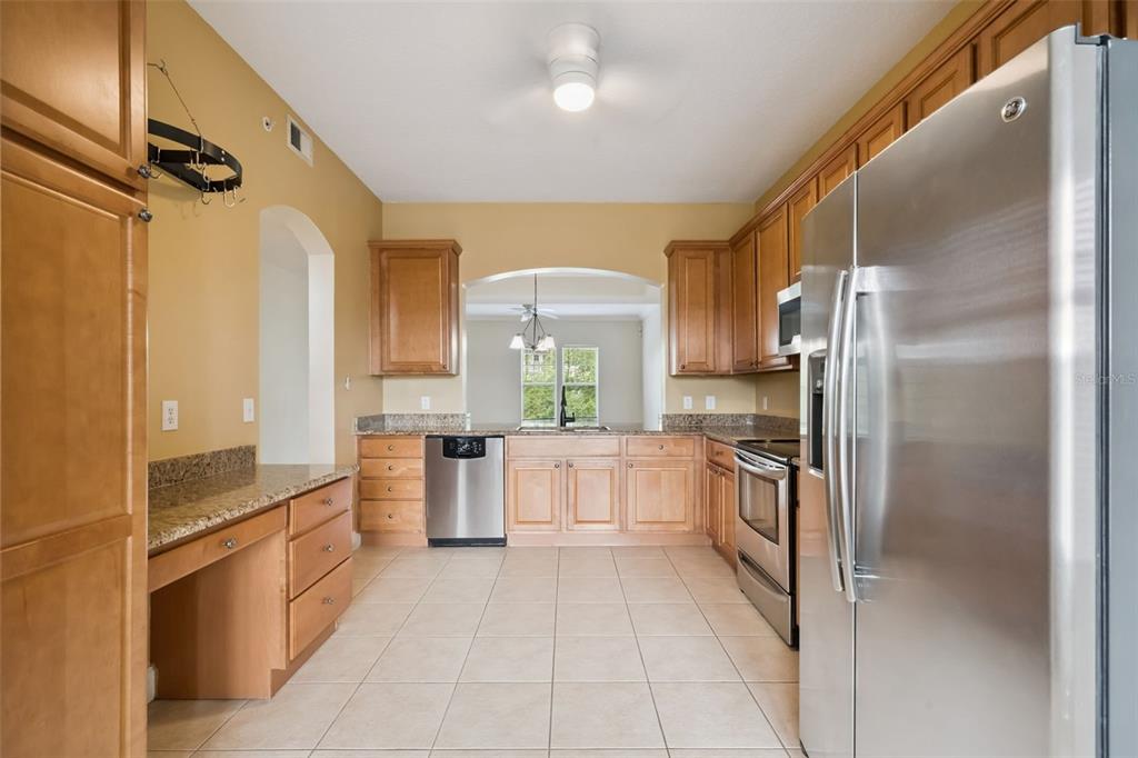 1400 Celebration Avenue, Unit 305 Celebration, FL 34747 - Photo 3 of 38 a large kitchen with cabinets and stainless steel appliances