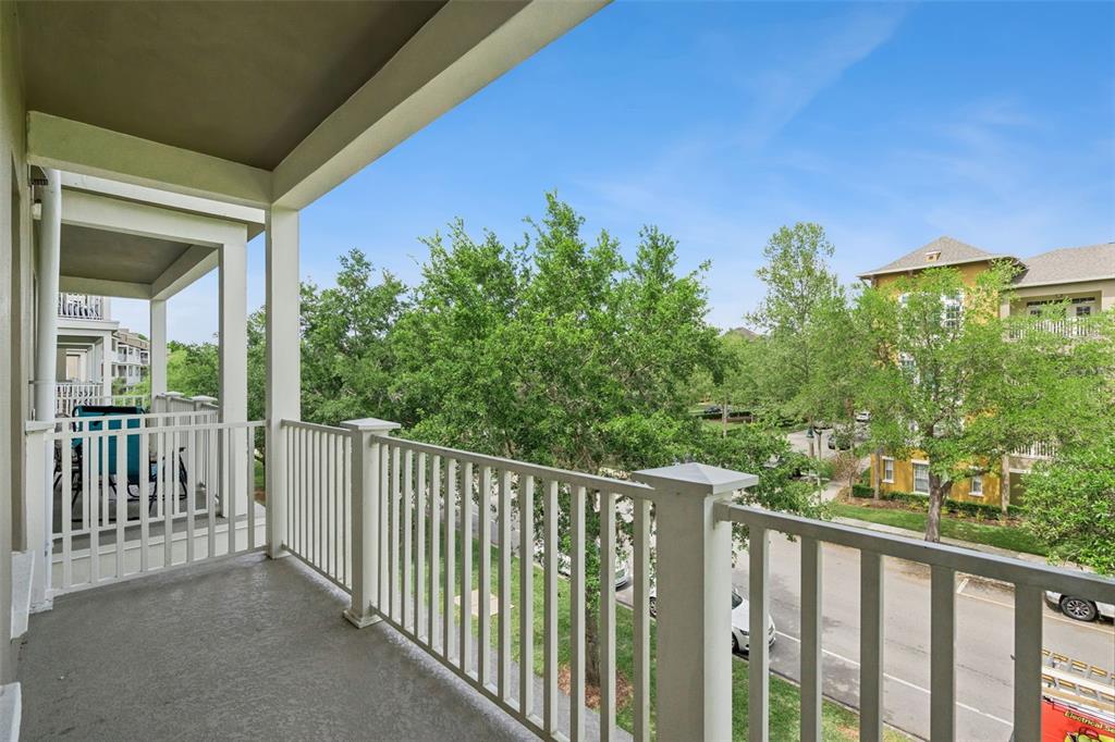 1400 Celebration Avenue, Unit 305 Celebration, FL 34747 - Photo 32 of 38 a balcony with trees in front of it