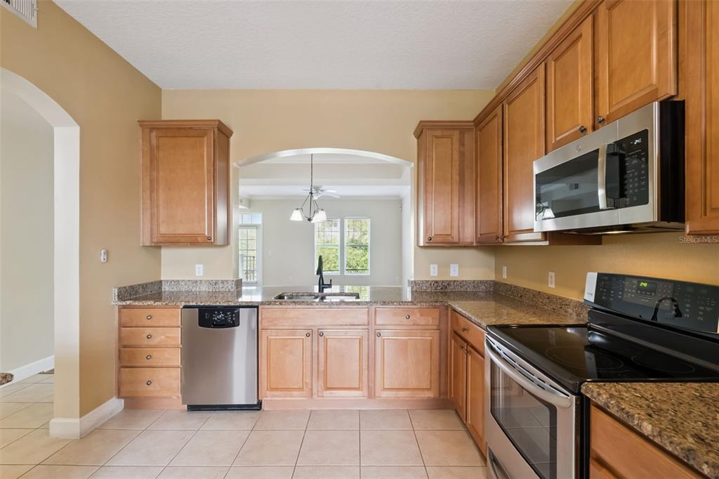 1400 Celebration Avenue, Unit 305 Celebration, FL 34747 - Photo 4 of 38 a kitchen with stainless steel appliances a stove sink and microwave