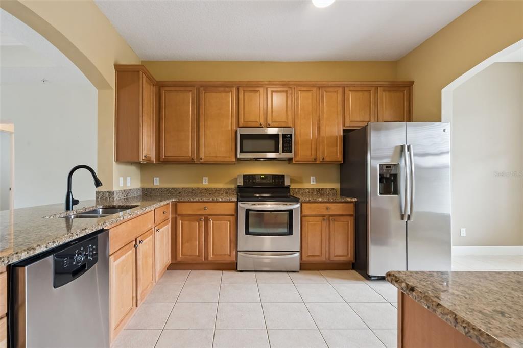 1400 Celebration Avenue, Unit 305 Celebration, FL 34747 - Photo 6 of 38 a kitchen with granite countertop a stove sink and refrigerator
