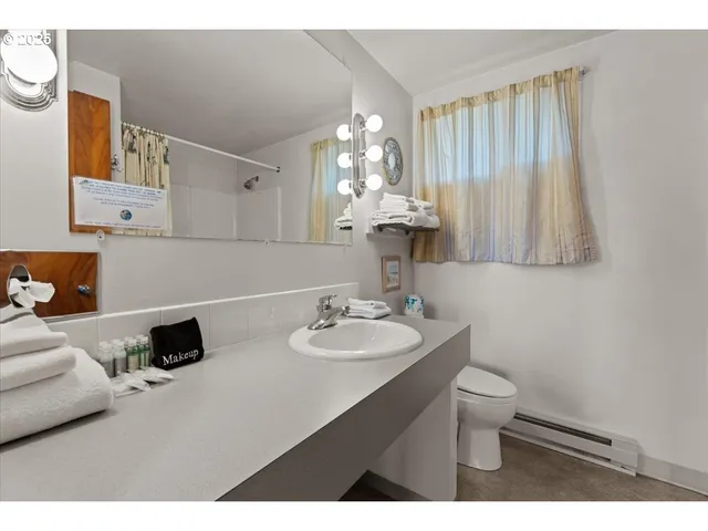 a bathroom with a sink toilet and a mirror