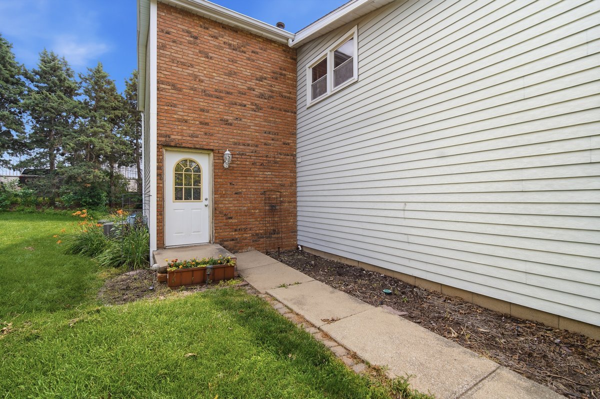 1532 Hunt Drive, Unit A Normal, IL 61761 - Photo 2 of 25 a view of a backyard with plants and a tree