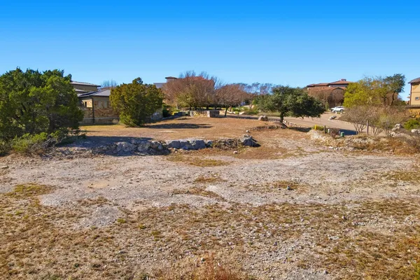 a view of a dry yard with wooden fence